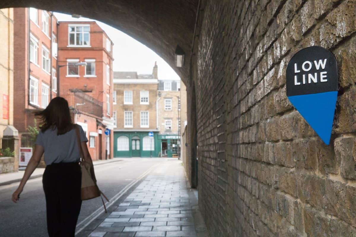 Image of a woman walking under an arch with the low line marker in the foreground